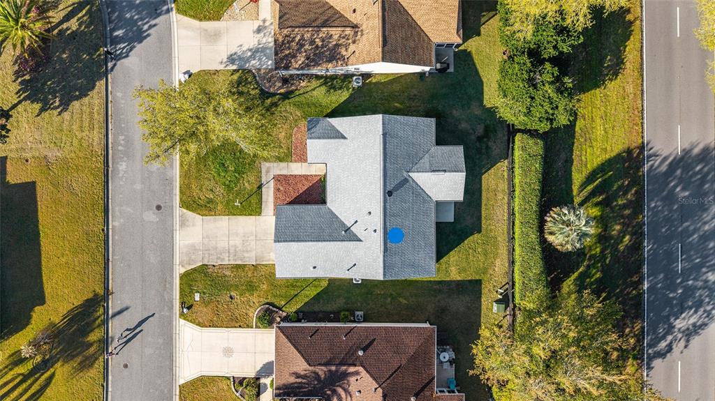 An aerial view shows a residential house with a gray roof and a blue dot — 1449 MURRELLS INLET LOOP, THE VILLAGES, FL