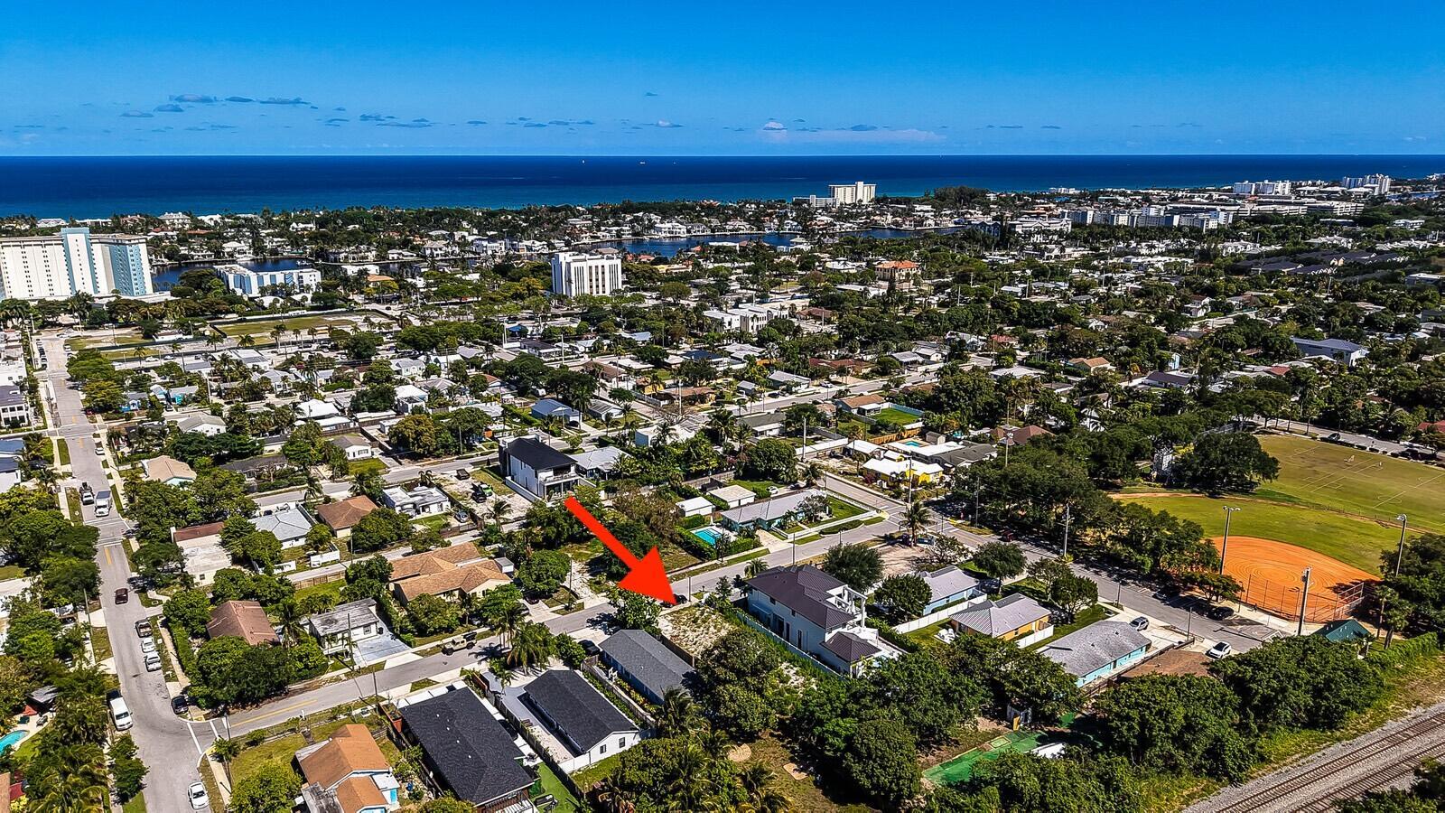 An aerial view shows a vacant residential lot situated between two modern houses in a neighborhood — 618 SE 2nd Avenue, Delray Beach FL 33483, DELRAY BEACH, FL
