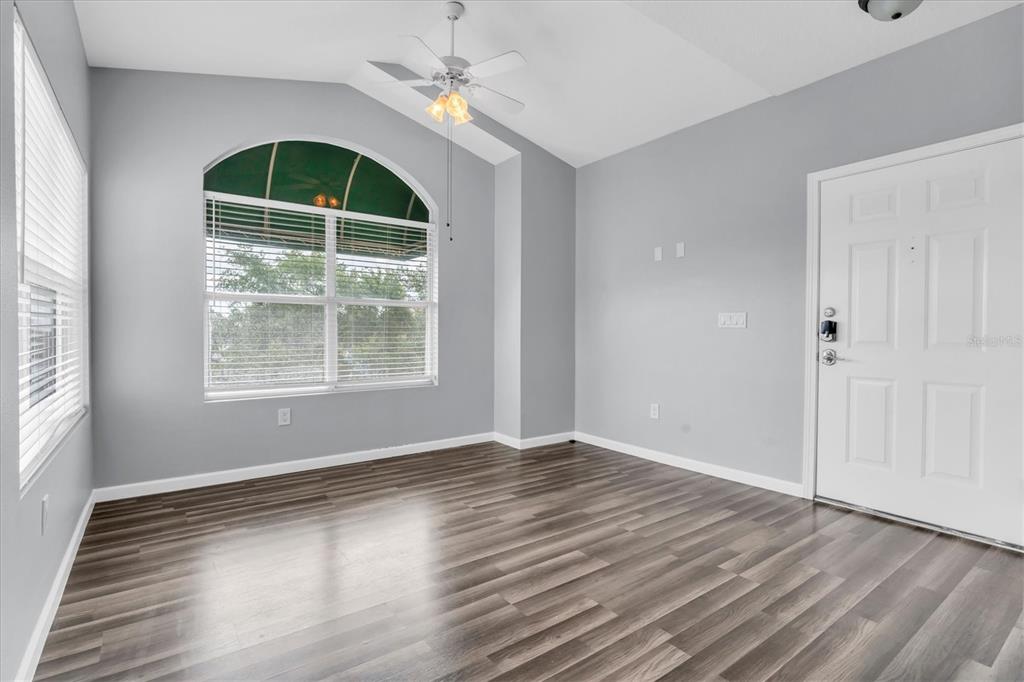 An empty room with gray walls, wood-look flooring, a ceiling fan, and an arched window — 10764 70TH AVENUE UNIT 3307, SEMINOLE, FL
