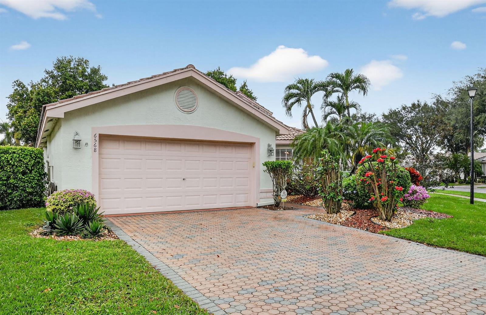 A light-colored house with a pink garage door and a patterned paver driveway — 6568 Malta Drive, Boynton Beach FL 33437, BOYNTON BEACH, FL