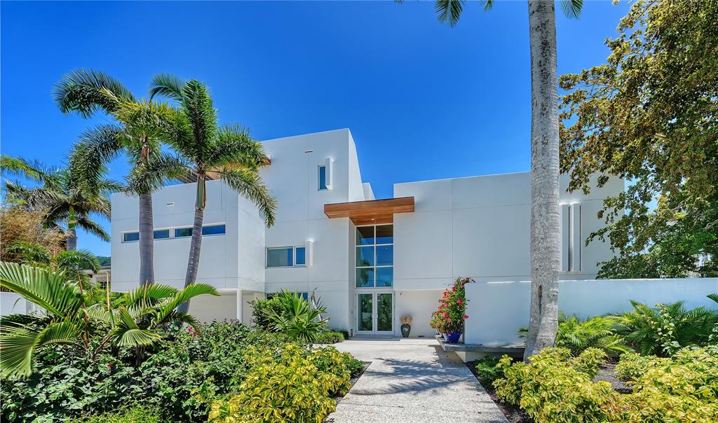 A modern white two-story house features a glass entryway, flat roof, and lush tropical landscaping — 246 MORNINGSIDE DRIVE, SARASOTA, FL