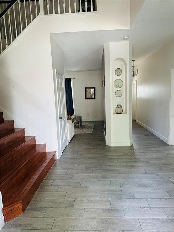 An entryway features wood stairs, gray tile flooring, and a central wall with an arched niche — 2283 STONE CROSS CIRCLE, ORLANDO, FL