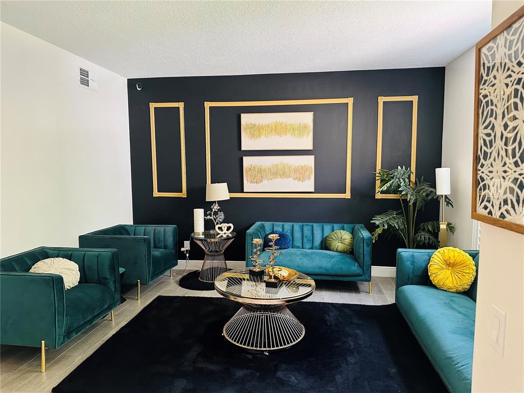 A living room features teal velvet furniture, a black area rug, and a gold-accented black wall — 2283 STONE CROSS CIRCLE, ORLANDO, FL