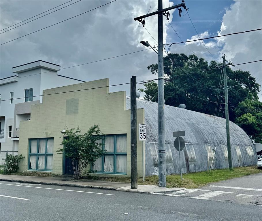 An exterior view of a light-colored building with a curved metal roof and windows — 3205 N FLORIDA AVENUE, TAMPA, FL