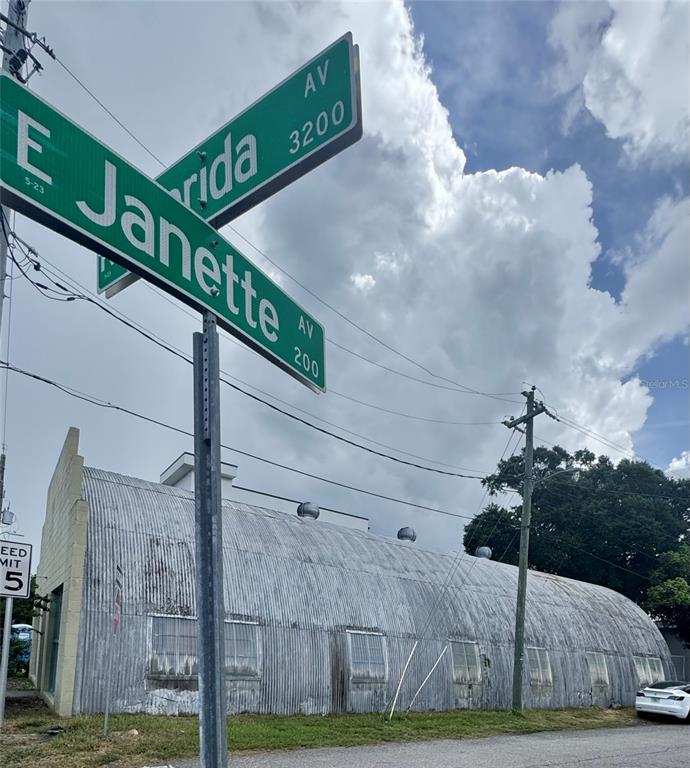 A corrugated metal Quonset hut building stands at the corner of two street signs — 3205 N FLORIDA AVENUE, TAMPA, FL