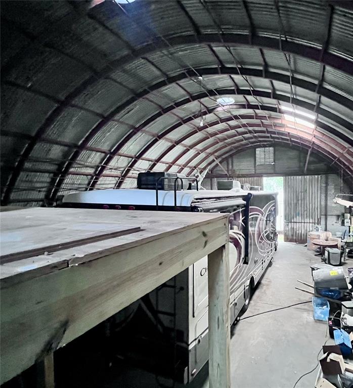 A large RV is parked inside a metal Quonset-style storage building with a wooden loft — 3205 N FLORIDA AVENUE, TAMPA, FL