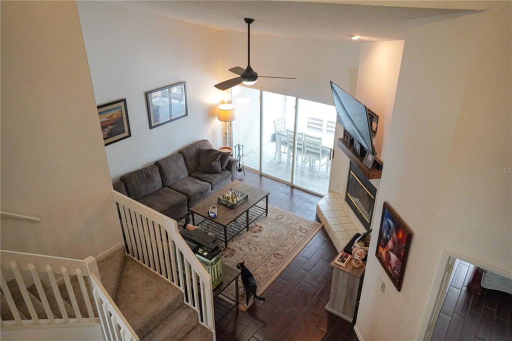 A high-angle view of a living room with a fireplace, sofa, and staircase — 1963 GEORGIA CIRCLE N, CLEARWATER, FL