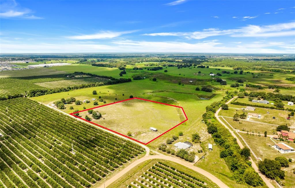 An aerial view shows a rectangular plot of land outlined in red amidst rural fields — SMITH ROAD, GROVELAND, FL