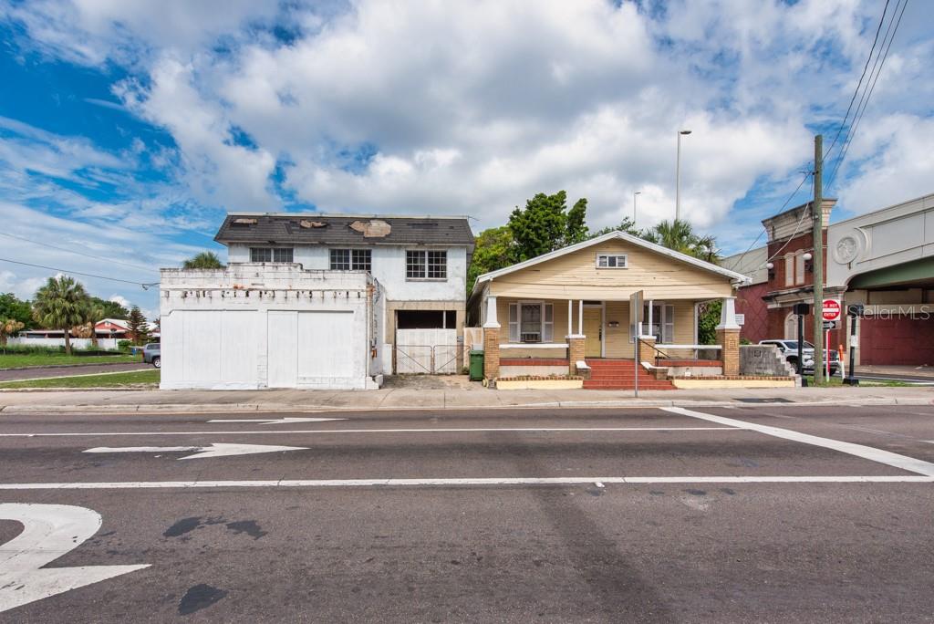 An exterior view of a two-story white building and a yellow house on a street — 1406 N HOWARD AVENUE, TAMPA, FL