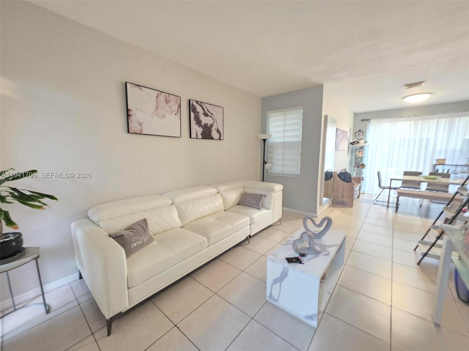 A living room features a white leather sofa, marble-patterned coffee table, and light tile flooring — 11702 SW 137th Pl, Miami FL 33186, MIAMI, FL