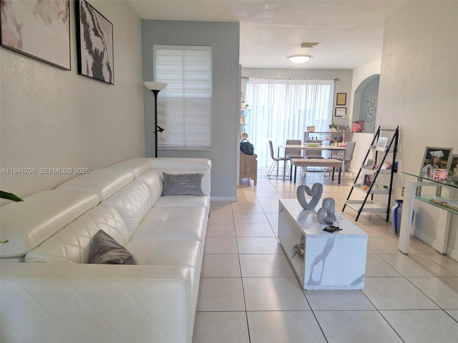 A living room features a white leather sofa, marble-patterned coffee table, and tile flooring — 11702 SW 137th Pl, Miami FL 33186, MIAMI, FL