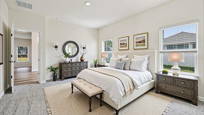 A bedroom features a bed with white bedding, a dresser, and a doorway to another room — 24258 NW 13TH BOULEVARD, NEWBERRY, FL