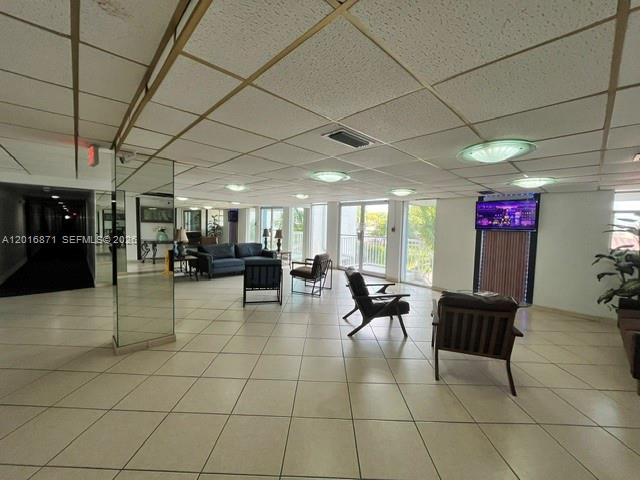 A spacious lobby features a tiled floor, drop ceiling, and several seating areas — 5050 NW 7th St # 220, Miami FL 33126, MIAMI, FL