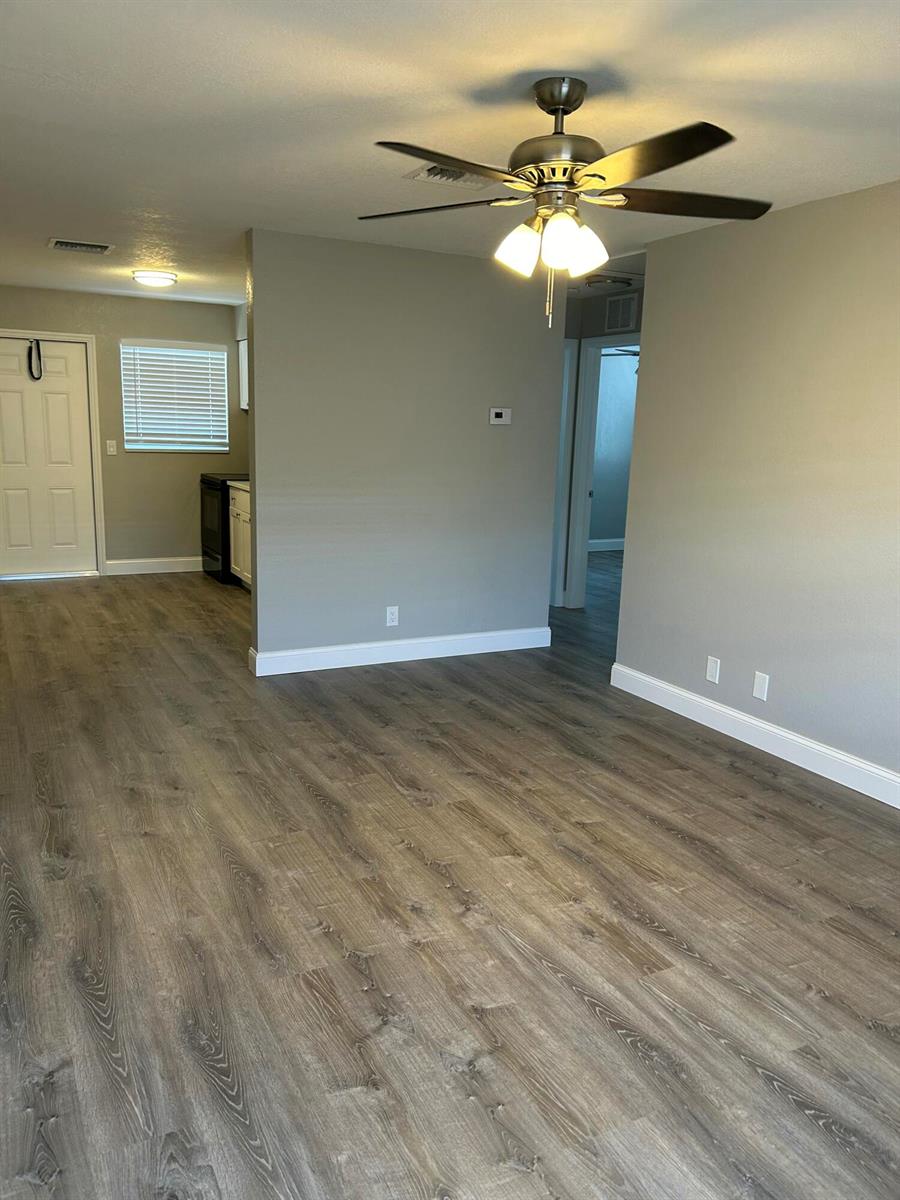 An open-concept living area features gray walls, wood-look flooring, and a ceiling fan — 628 N M Street, FL 33460, FL
