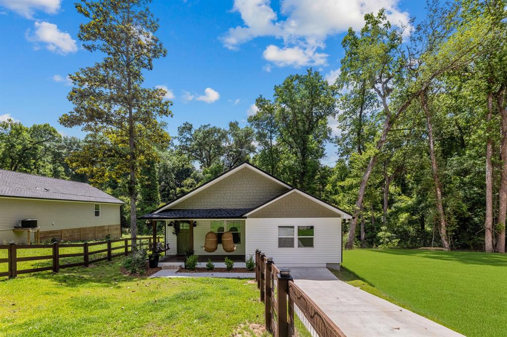 A single-story house with white siding, a green shingled gable, and a front porch — 618 N STEWART STREET, QUINCY, FL