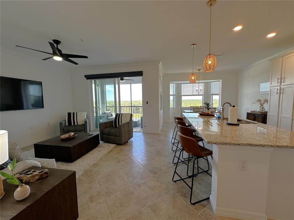 An open-concept living and kitchen area features tile flooring, a granite island, and a balcony — 14041 HERITAGE LANDING BOULEVARD UNIT 642, PUNTA GORDA, FL
