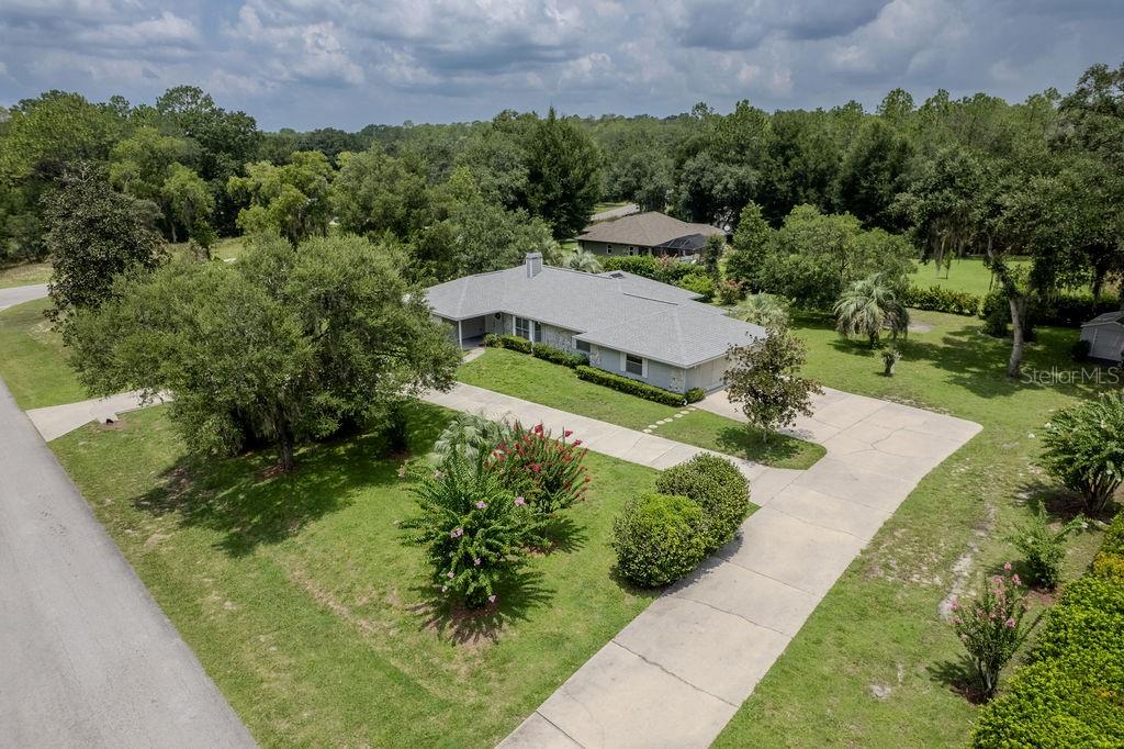 An aerial view shows a single-story house with a gray roof and a concrete driveway — 9501 SW 207TH CIRCLE, DUNNELLON, FL
