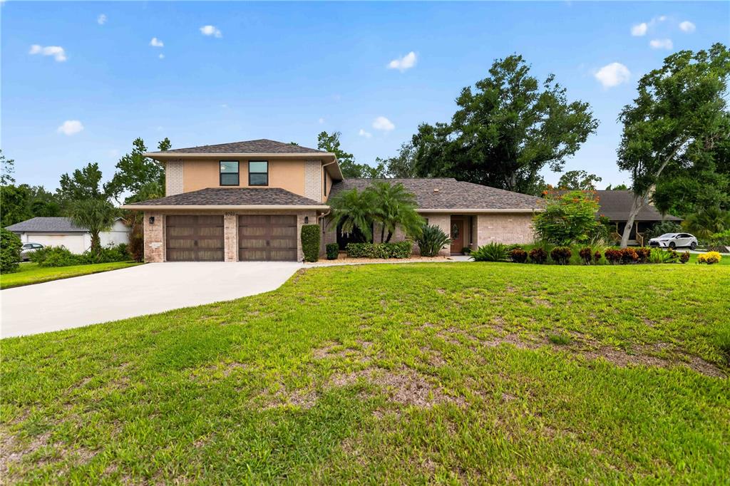 A two-story house with a brick facade, two-car garage, and a large front lawn — 9703 65TH AVENUE E, BRADENTON, FL