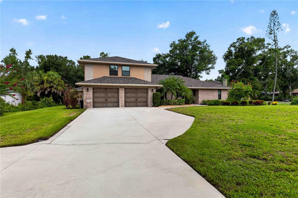 A two-story house with a two-car garage and a concrete driveway sits on a lawn — 9703 65TH AVENUE E, BRADENTON, FL
