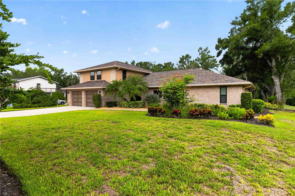 A two-story brick house with a multi-car garage and a large front lawn — 9703 65TH AVENUE E, BRADENTON, FL