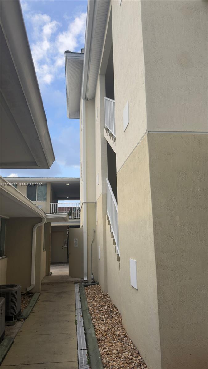An exterior view shows a narrow walkway between two multi-story apartment buildings with staircases — 1025 SW 7th Ave # 6, Miami FL 33130, MIAMI, FL