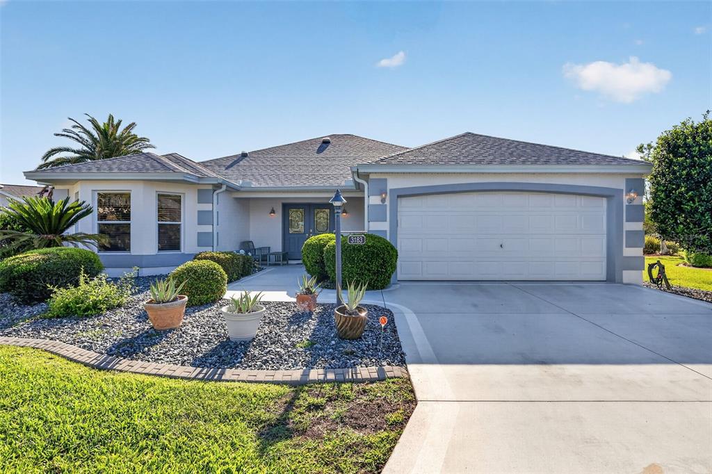A single-story house with a gray roof, white stucco walls, and a two-car garage — 3183 KEARNS CORNER, THE VILLAGES, FL