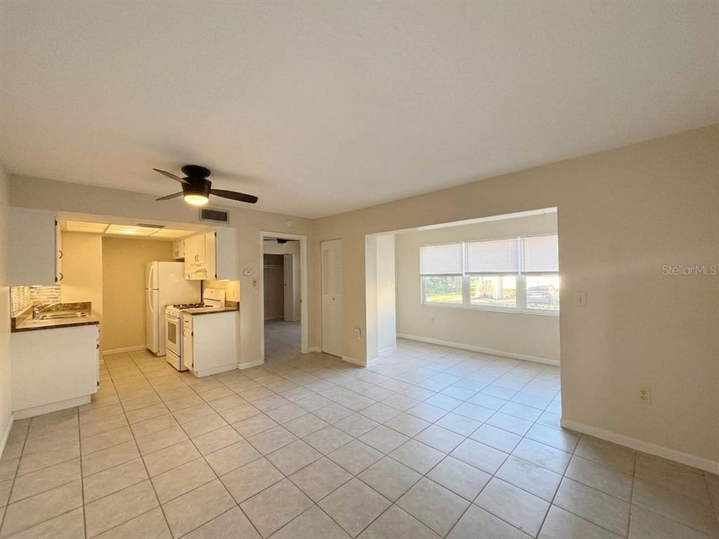 A tiled living area opens to a kitchen with white cabinets and a dining nook — 1103 CYPRESS GARDENS BOULEVARD UNIT 30, WINTER HAVEN, FL