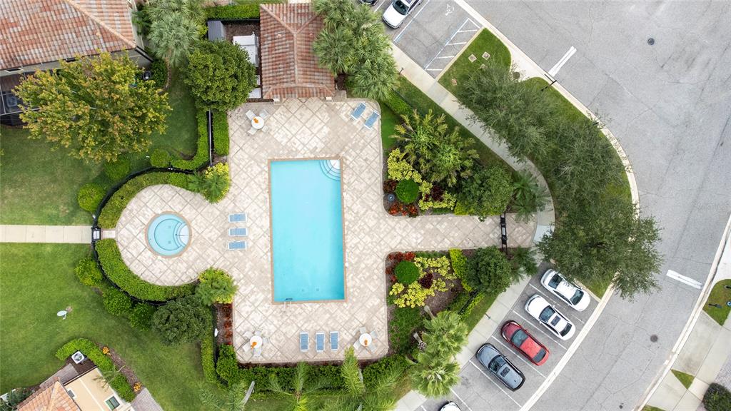 An aerial view shows a community swimming pool and spa surrounded by parking and landscaping — 8349 KELSALL DRIVE, ORLANDO, FL
