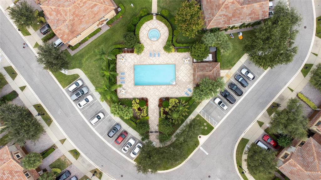 An aerial view shows a residential community with townhomes, a swimming pool, and a lake — 8349 KELSALL DRIVE, ORLANDO, FL