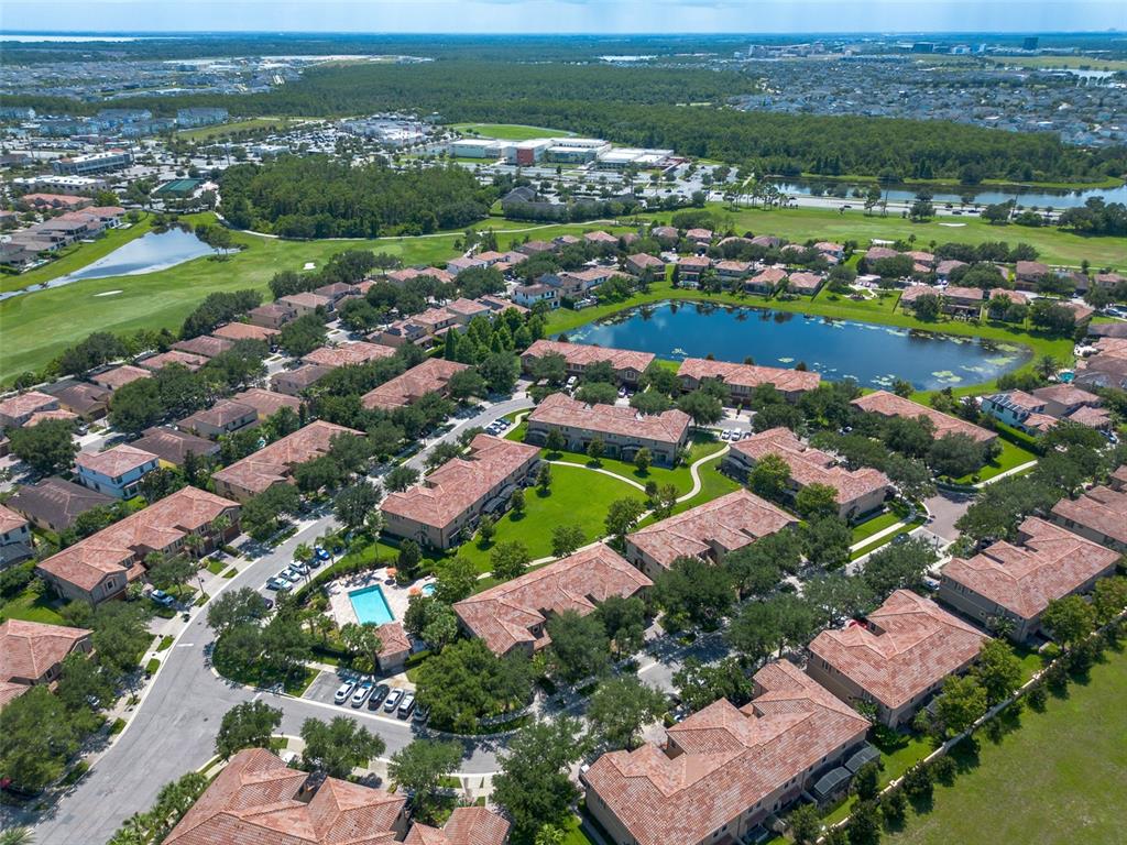 A view of a golf course green surrounded by sand bunkers, water, and trees — 8349 KELSALL DRIVE, ORLANDO, FL