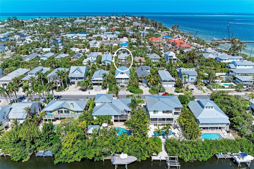 An aerial view shows a coastal neighborhood with a circled house near the water — 517 SPRING AVENUE, ANNA MARIA, FL