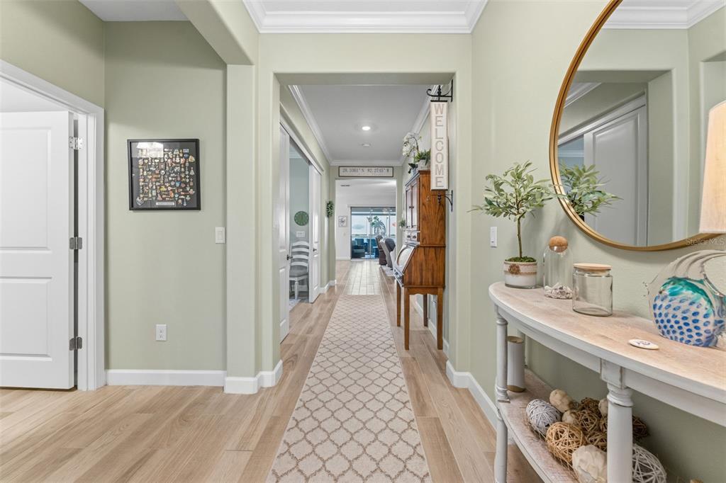 A light-filled entryway features light wood flooring, a console table, and a long hallway — 31493 CANNON RUSH DRIVE, SAN ANTONIO, FL