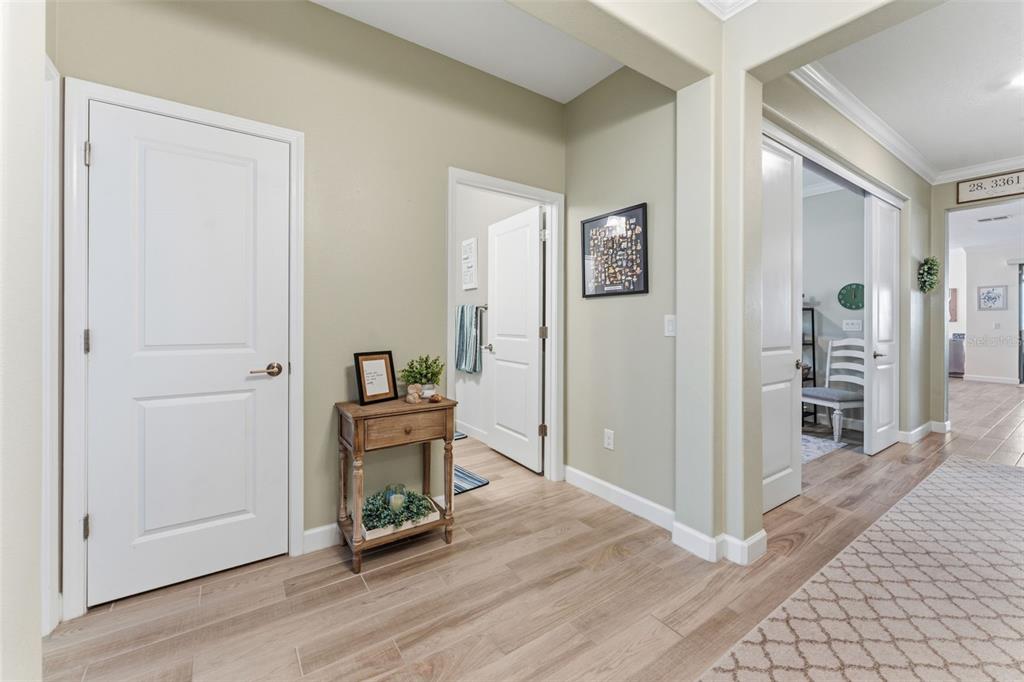 A hallway features light wood-look tile flooring, neutral walls, and several white interior doors — 31493 CANNON RUSH DRIVE, SAN ANTONIO, FL