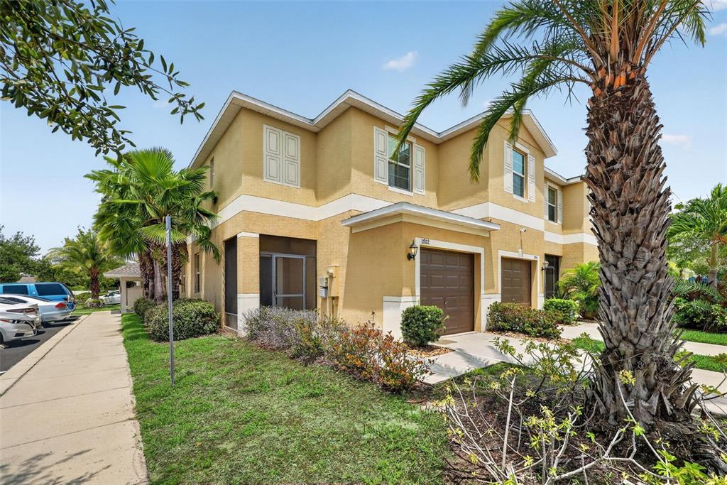 An aerial view shows a multi-unit residential building with a red arrow pointing to a unit — 1702 IVORY GOOSE PLACE, RUSKIN, FL