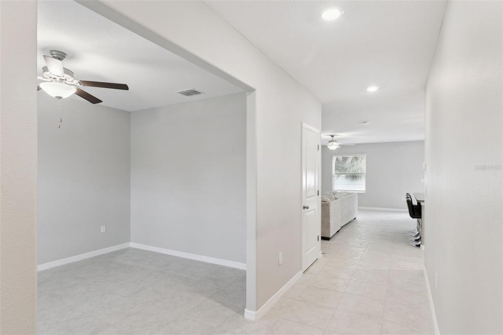 A view from a hallway into a dining area with a ceiling fan and tile flooring — 4918 WILD SENNA BOULEVARD, TAMPA, FL