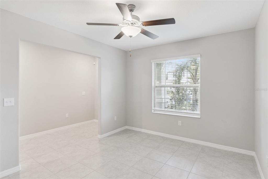 A room with light gray walls, tile flooring, a ceiling fan, and a window with blinds — 4918 WILD SENNA BOULEVARD, TAMPA, FL