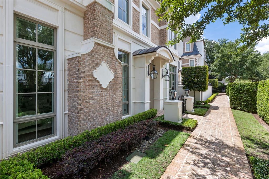 A brick walkway leads along the side of a multi-story house with stone accents — 649 N PARK AVENUE, WINTER PARK, FL