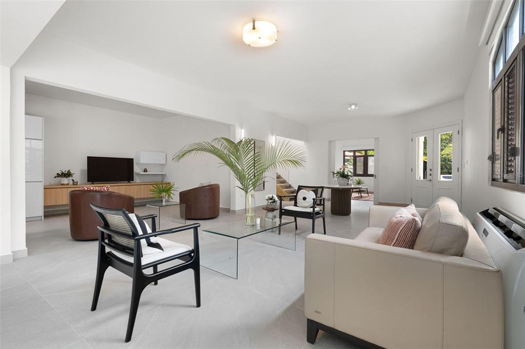 A bright, open-concept living room features light tile floors, modern furniture, and a large plant — The Legends DORADO BEACH EAST UNIT 25, DORADO, PR