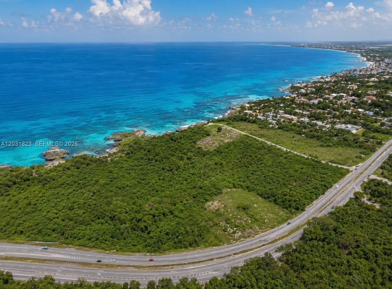 An aerial view shows a coastal highway bordering a large, undeveloped plot of green land — Autovia Del Este, PA 15400, PA