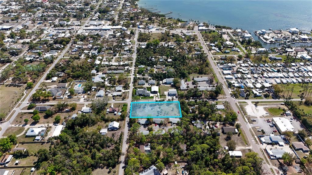 An aerial view shows a vacant, rectangular lot highlighted in blue within a residential neighborhood — 212 CEDAR STREET, ENGLEWOOD, FL