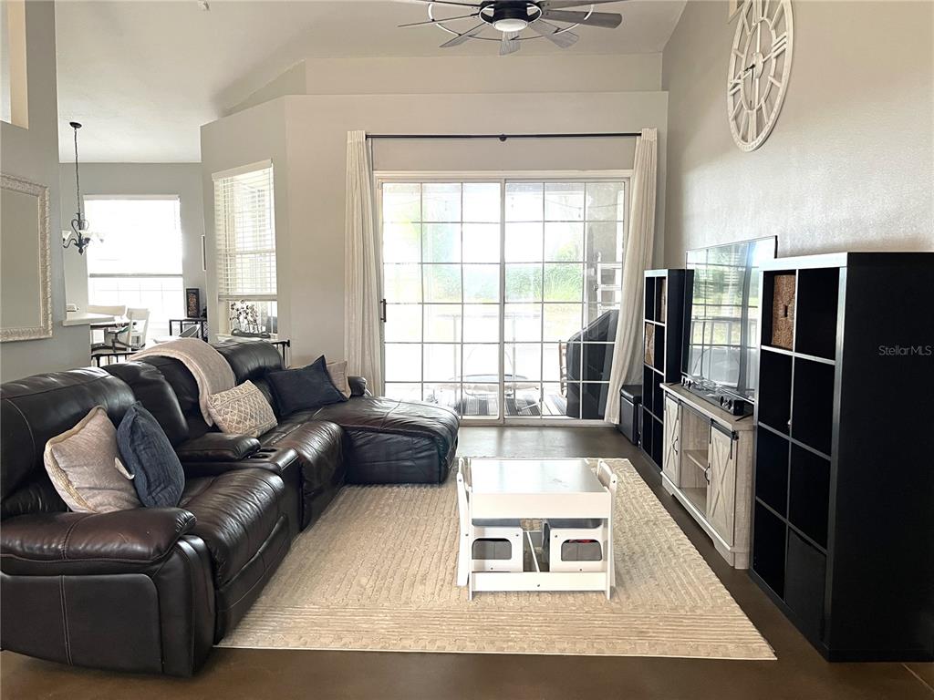 A living room features a leather sectional, a white coffee table, and a media console — 10839 LANTANA CREST, CLERMONT, FL