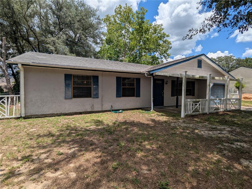 A single-story house with a stucco exterior, blue shutters, and a covered front porch — 32 PALM RUN, OCALA, FL