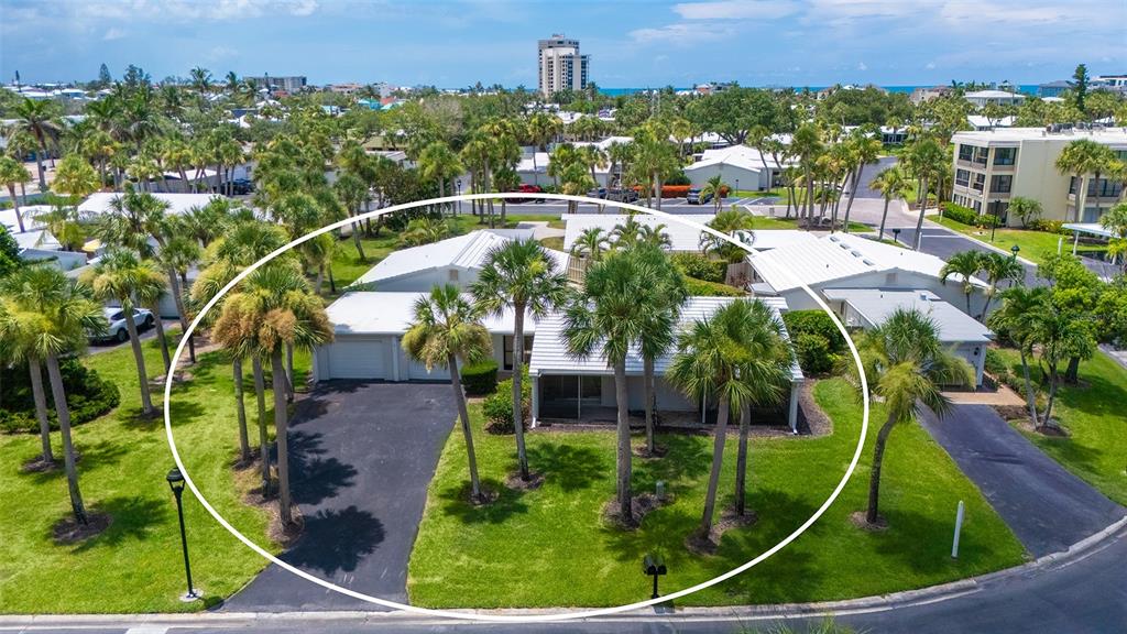 An aerial view of a single-story house with a white roof and a paved driveway — 208 HOURGLASS WAY UNIT V11, SARASOTA, FL