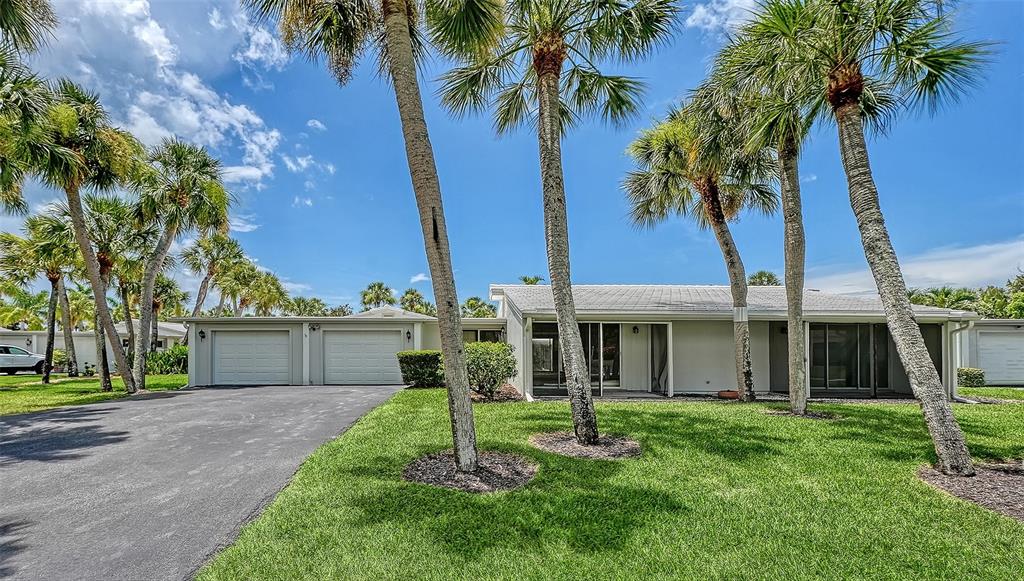 A single-story house with a two-car garage and palm trees in the front yard — 208 HOURGLASS WAY UNIT V11, SARASOTA, FL