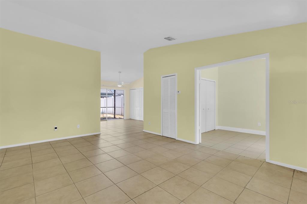 An interior view of a room with light yellow walls and beige tile flooring — 3143 STONECASTLE ROAD, ORLANDO, FL