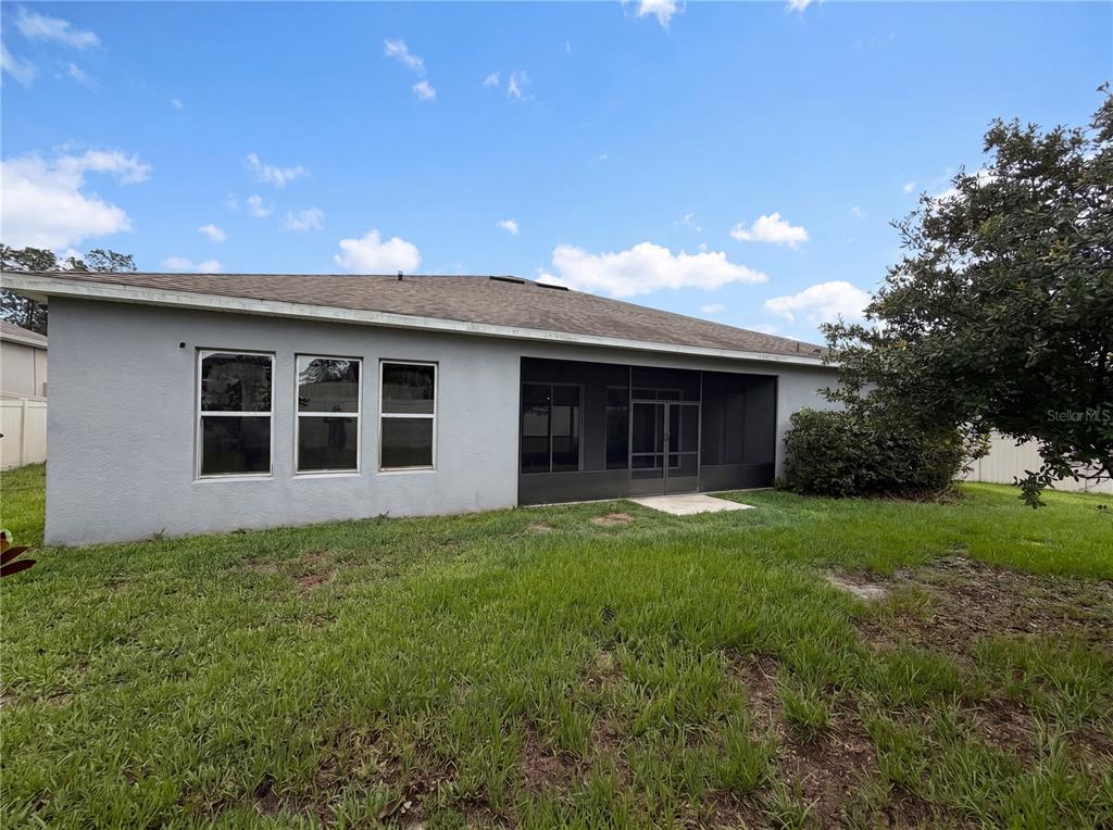 The exterior of a gray house features a screened-in patio and three windows — 432 NOWELL LOOP, DELAND, FL