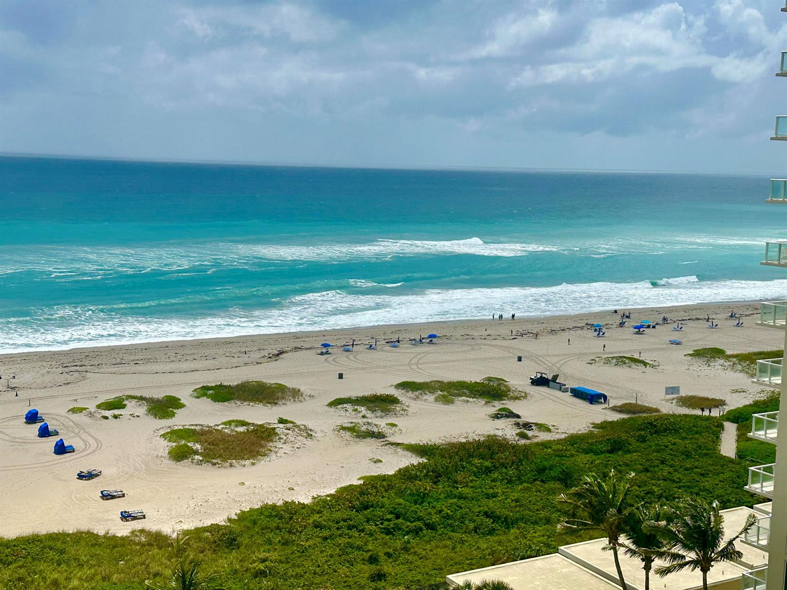An aerial view shows high-rise residential buildings lining a sandy beach along the ocean — 2800 N Ocean Drive # d, Singer Island FL 33404, SINGER ISLAND, FL