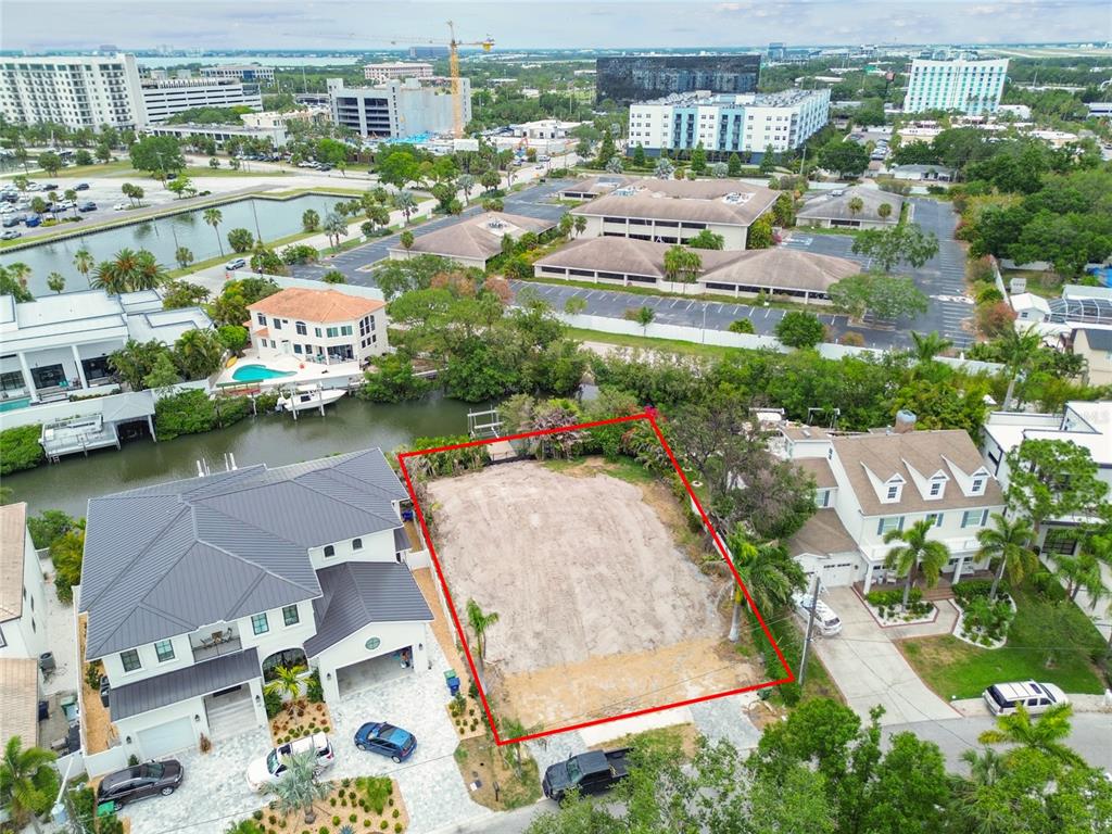 An aerial view shows a vacant, rectangular residential lot outlined in red between two houses — 17 W SPANISH MAIN STREET, TAMPA, FL