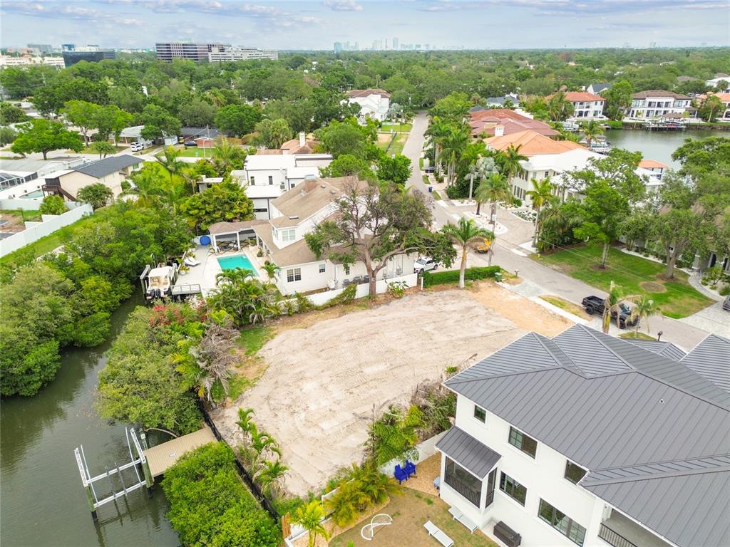 An aerial view shows a vacant waterfront lot situated between two large residential houses — 17 W SPANISH MAIN STREET, TAMPA, FL