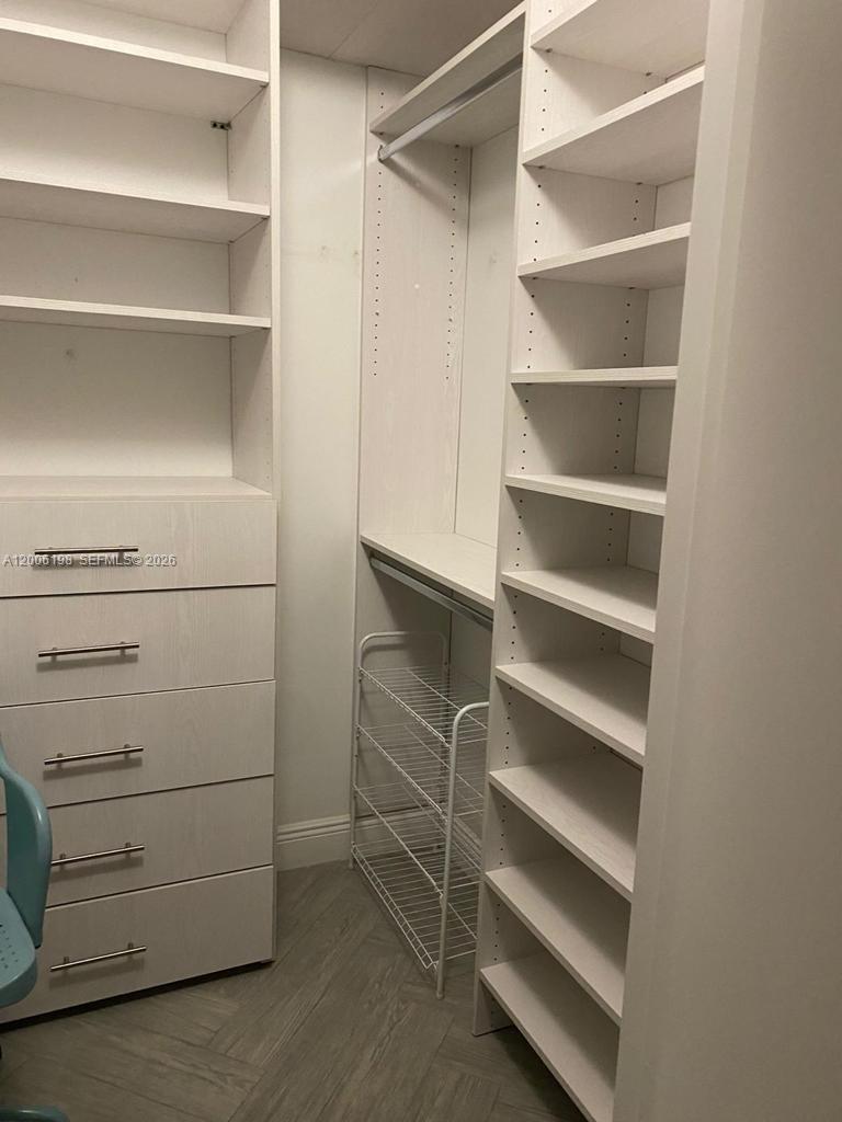 A walk-in closet features white shelving, a built-in dresser, and a wire shoe rack — 1900 N Bayshore Dr # 2314, Miami FL 33132, MIAMI, FL